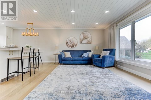 A living room with a blue couch and a rug.