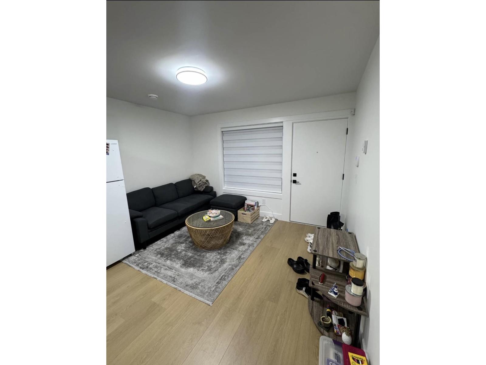 A room with a black sofa and a basket on the floor.