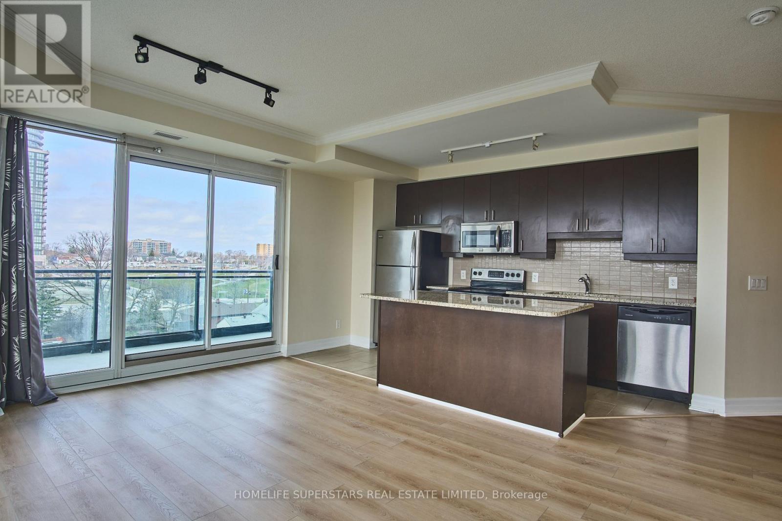 A kitchen with dark brown cabinets and a wooden island.