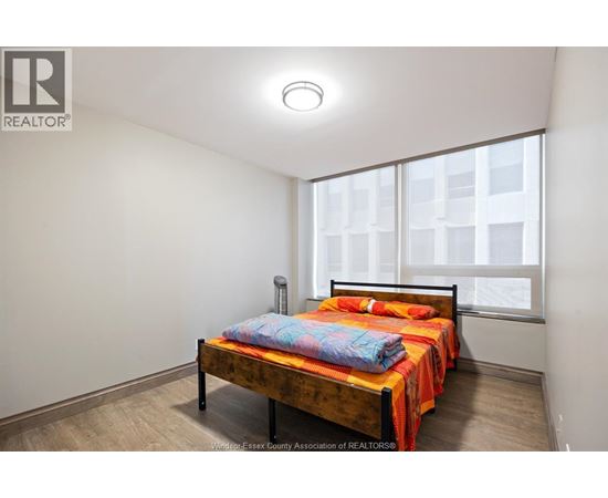 A bedroom with a bed and a window.