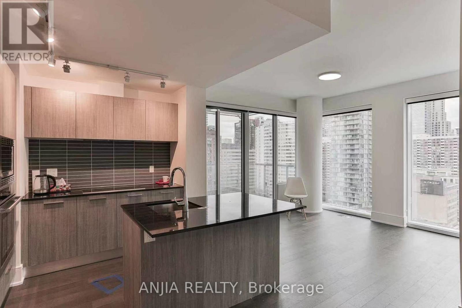 A modern kitchen with a large island and a view of the city.
