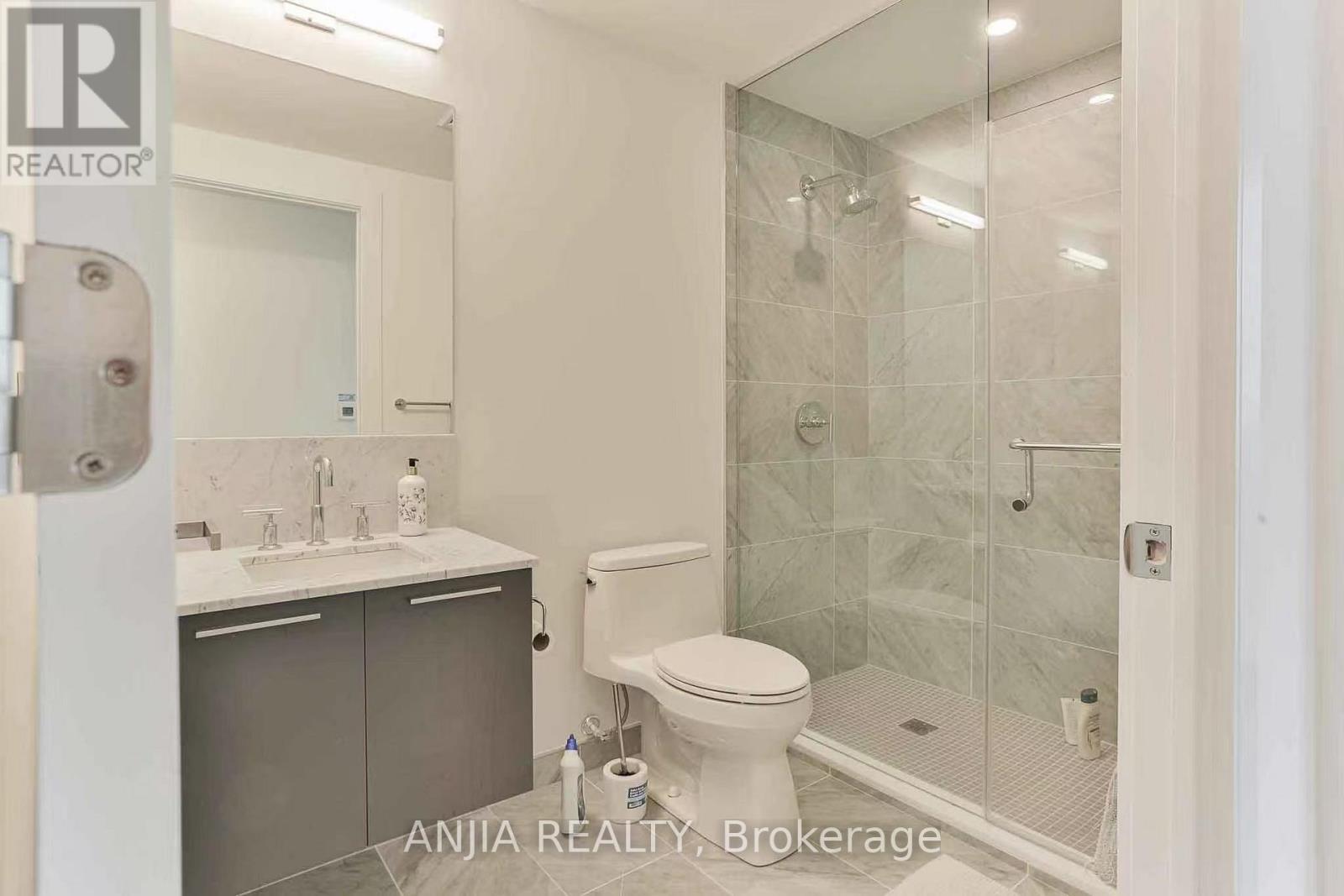 A bathroom with a toilet, sink, and shower.