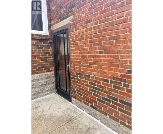 A brick wall with a door and a window.