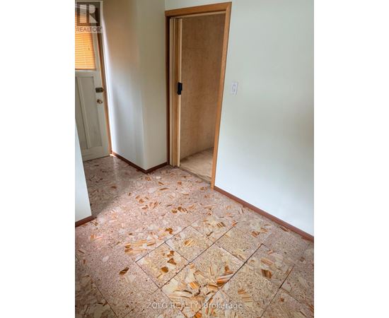 A room with a tile floor and a wooden door.