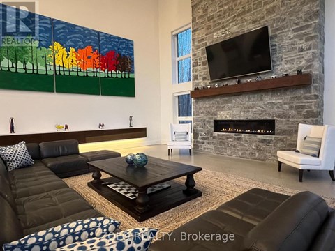 A living room with a stone fireplace and a painting on the wall.