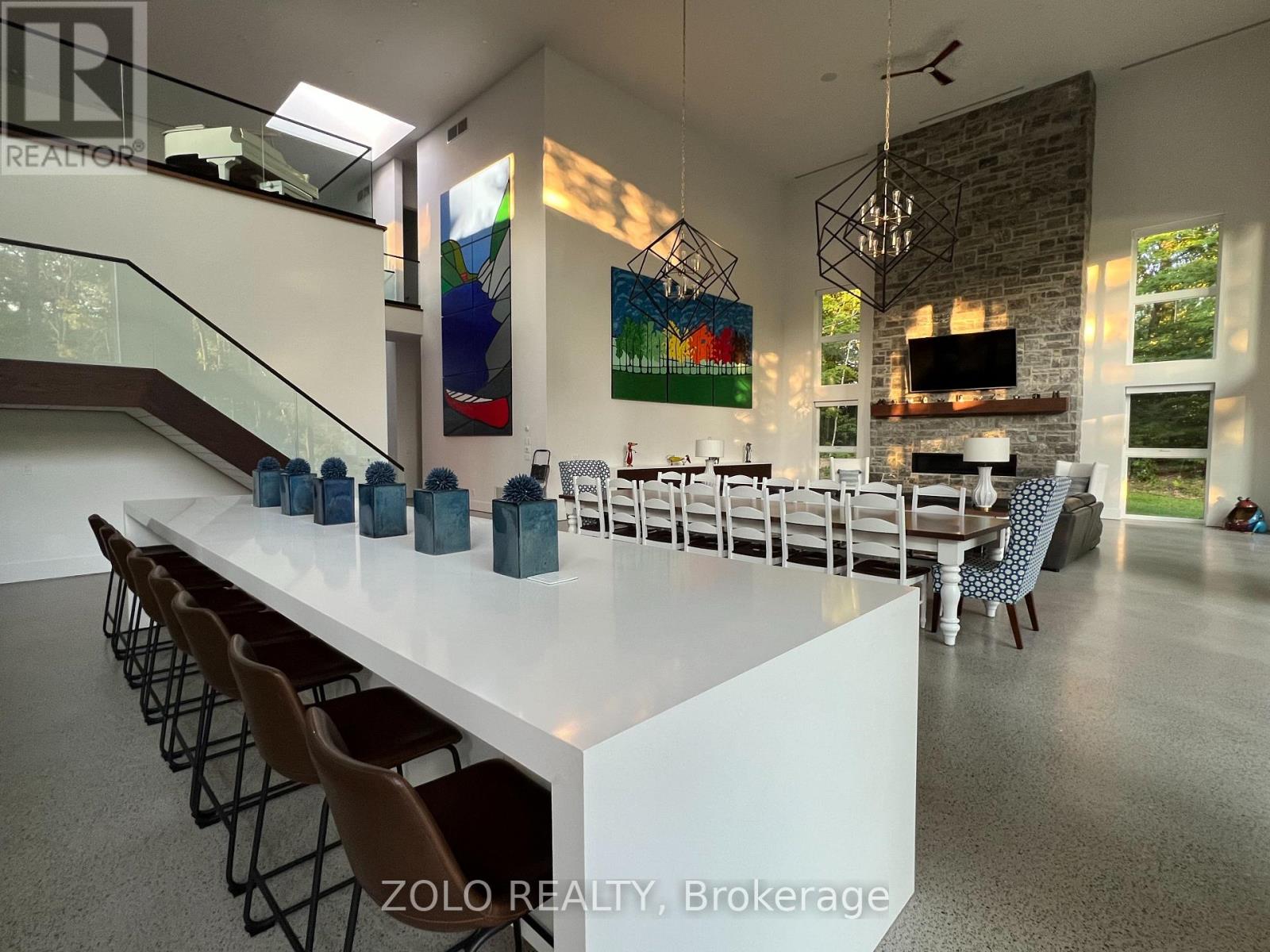 A modern dining room with a long white table and chairs.