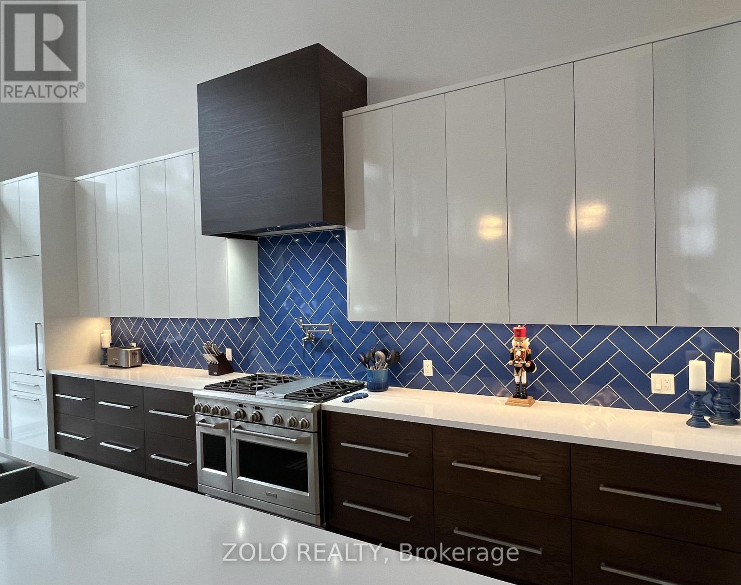 A kitchen with a blue tile backsplash and a stove top oven.
