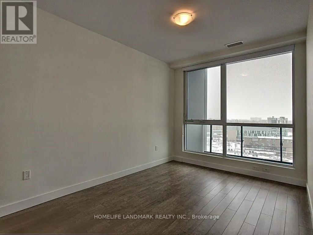 A room with a large window and wooden flooring.