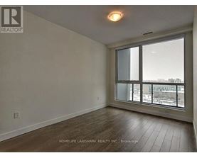 A room with a large window and wooden flooring.