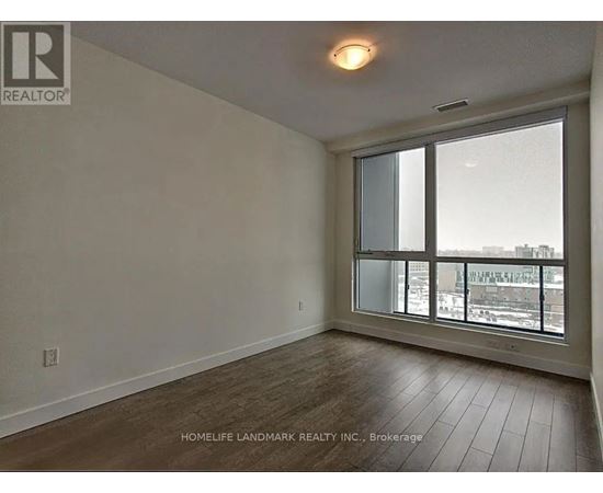A room with a large window and wooden flooring.