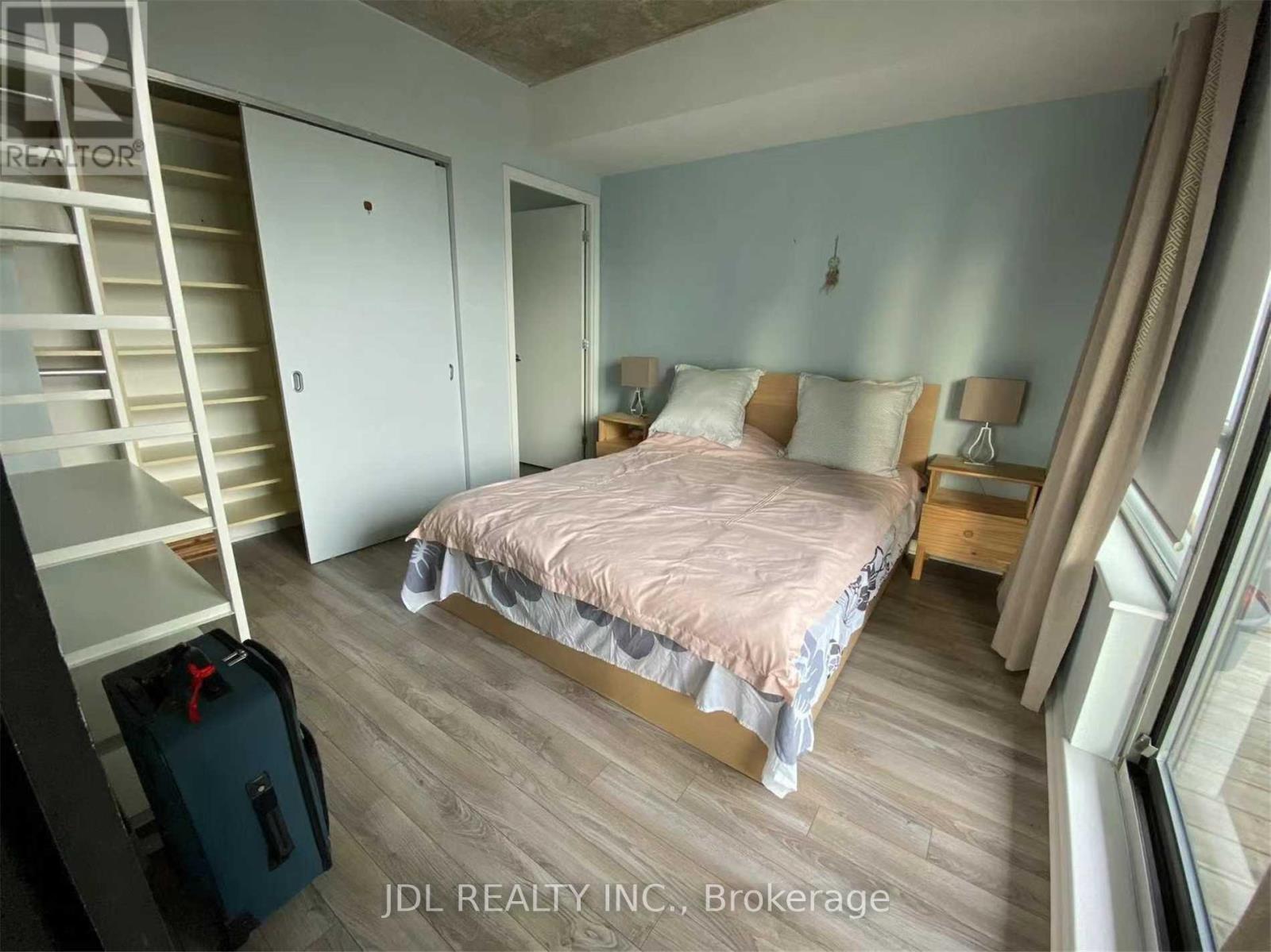 A bedroom with a bed, dresser, and a suitcase.