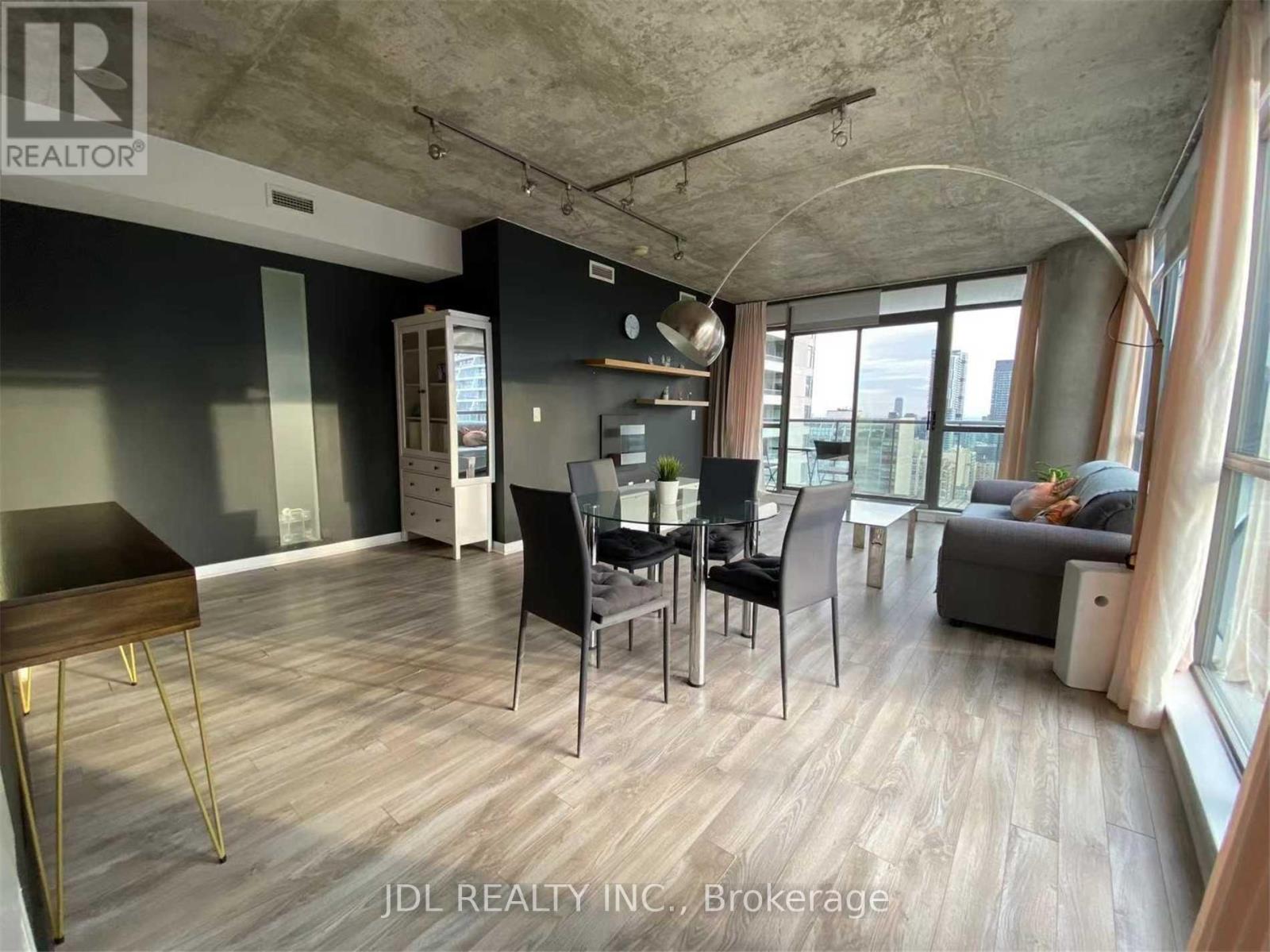 A modern living room with a dining area and a kitchenette.