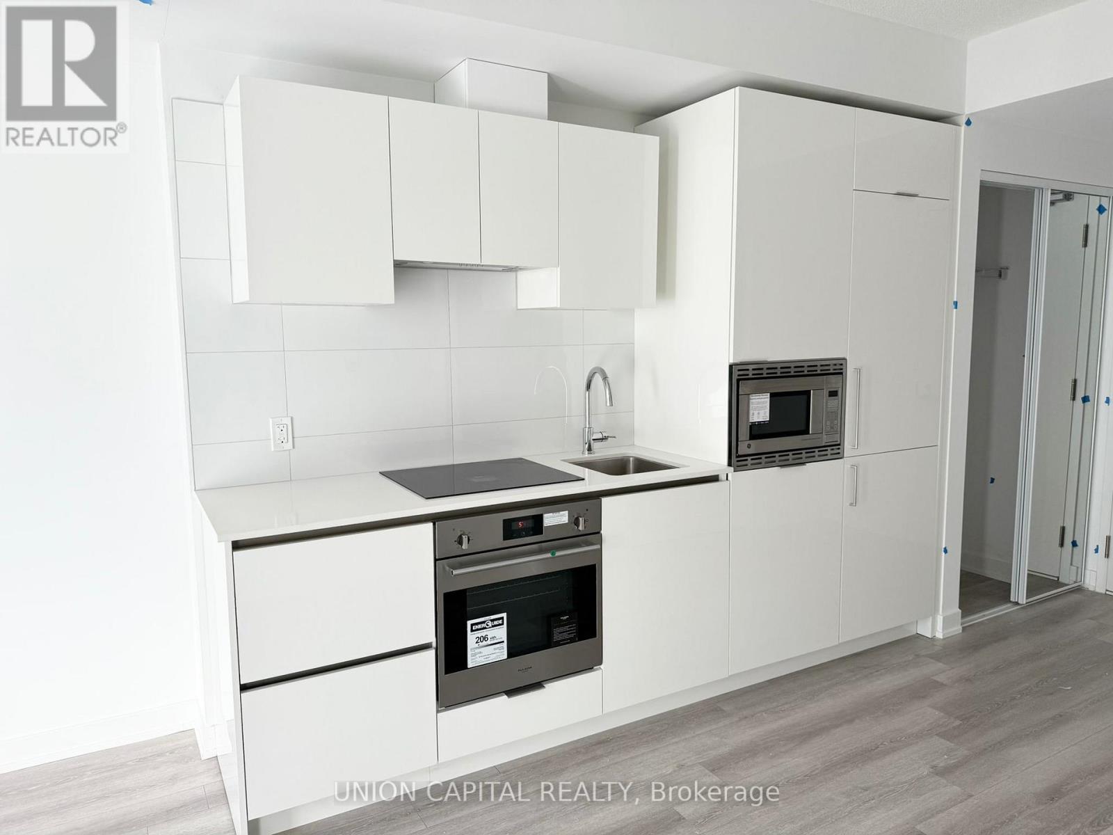 A kitchen with white cabinets and appliances.