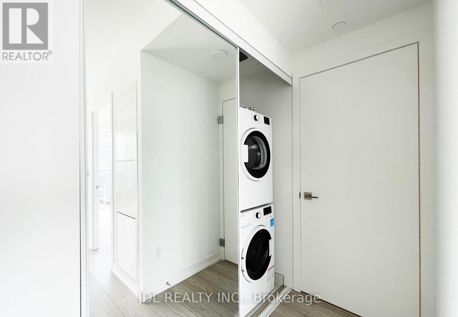 A white laundry room with a washer and dryer built into the cabinetry.