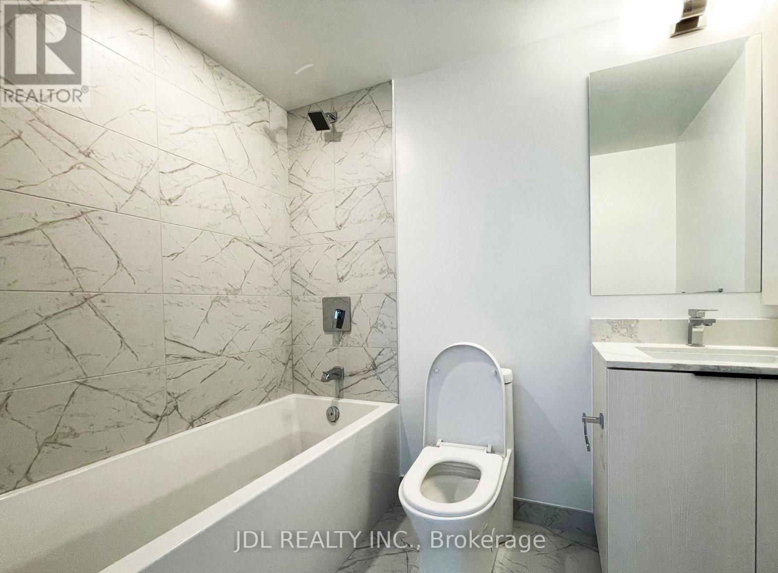 A bathroom with a bathtub, toilet, and sink.