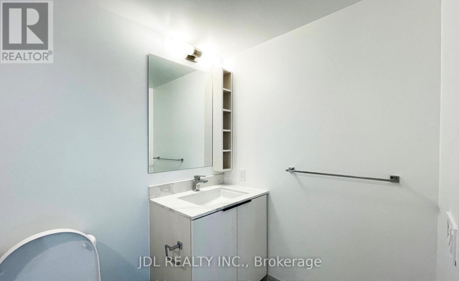 A bathroom with a sink, mirror, and towel rack.