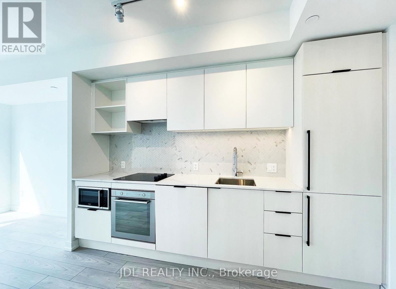 A white kitchen with a sink and oven.