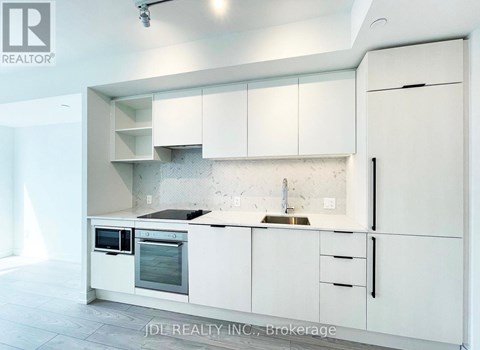A white kitchen with a sink and oven.