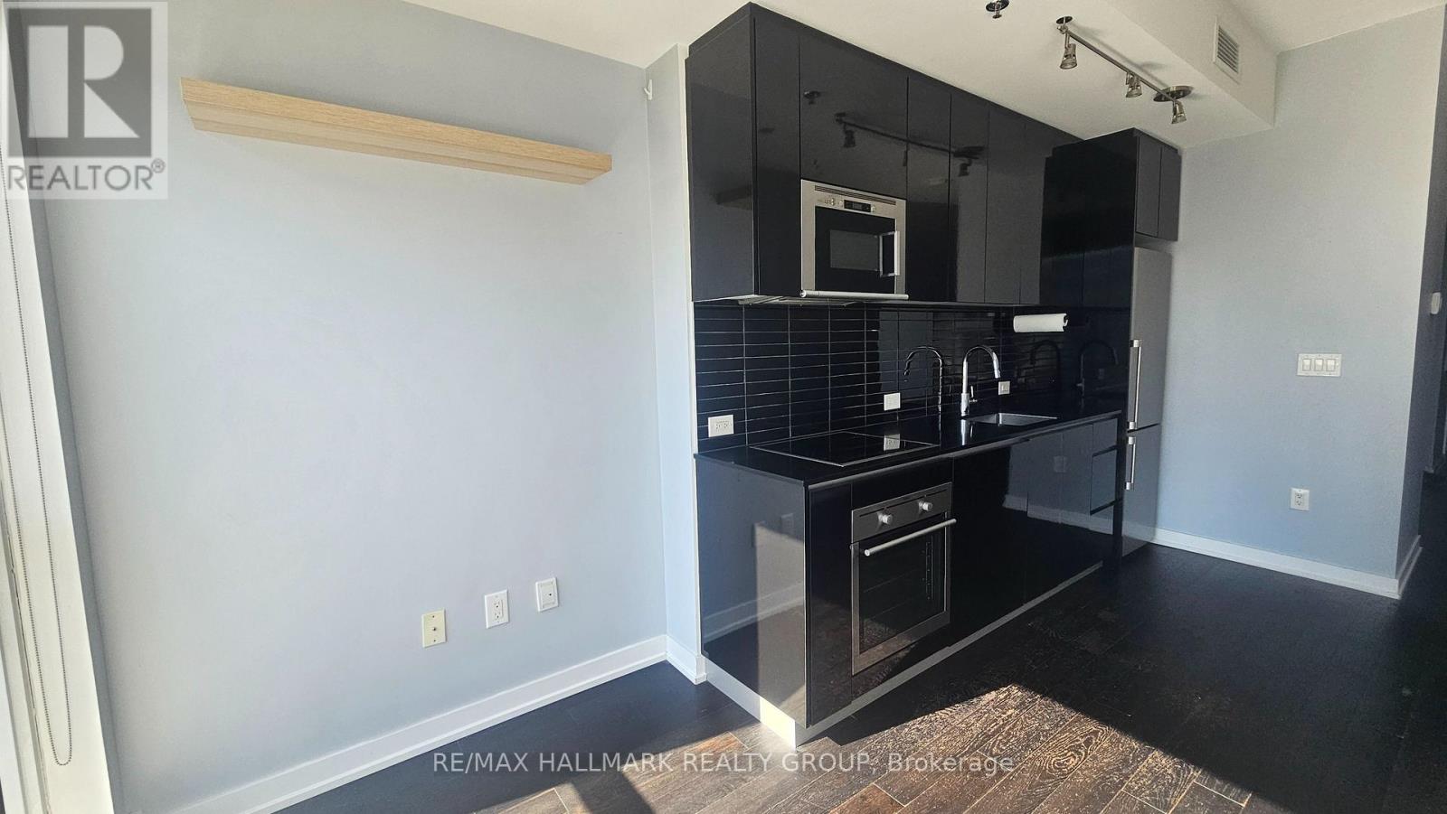 A kitchen with black countertops and a microwave above the stove.