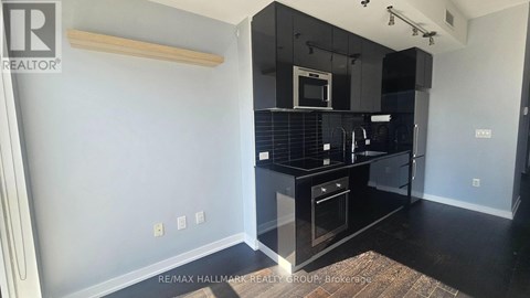 A kitchen with black countertops and a microwave above the stove.