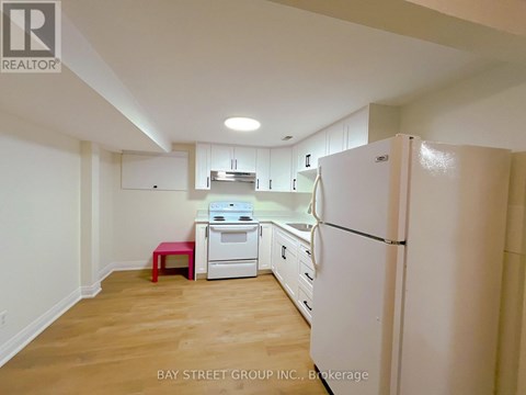 A kitchen with white appliances and wooden floors.