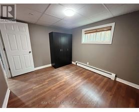 A room with a white door, a black cabinet, and a window with blinds.