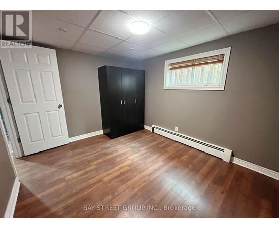 A room with a white door, a black cabinet, and a window with blinds.