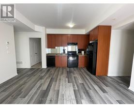 A kitchen with wooden cabinets and a black fridge.