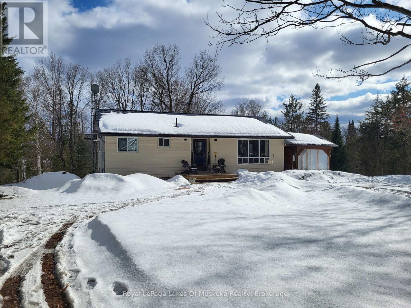 A house with a snow-covered ground in front of it.