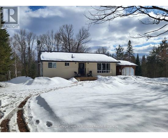 A house with a snow-covered ground in front of it.