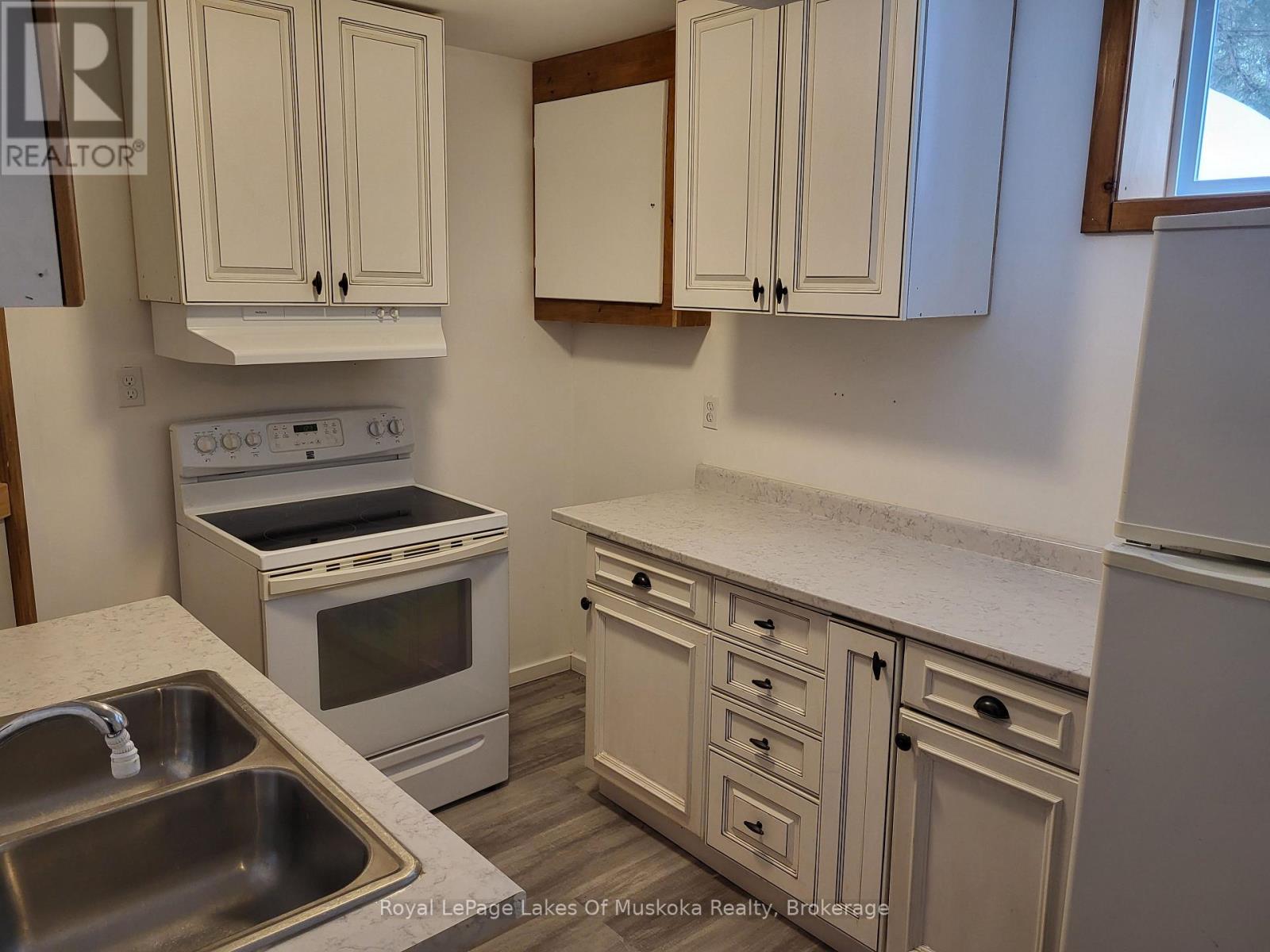 A kitchen with white cabinets and a stove top oven.