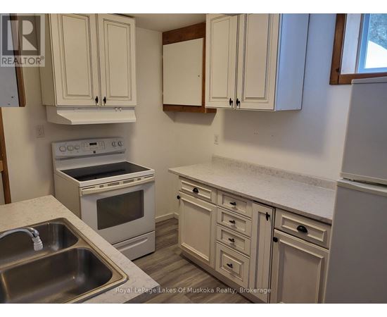 A kitchen with white cabinets and a stove top oven.