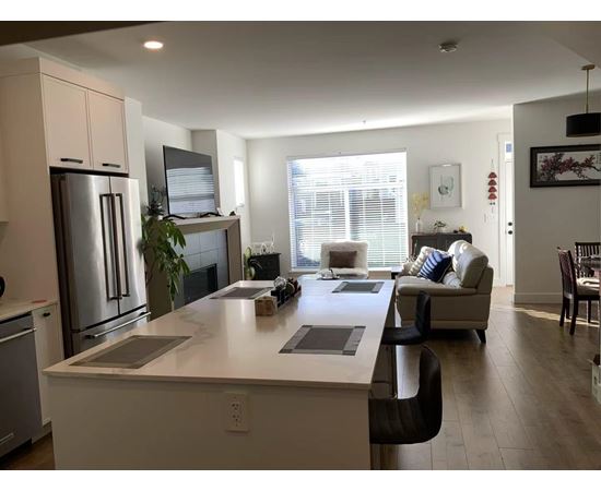 A modern kitchen with a refrigerator, stove, and oven.