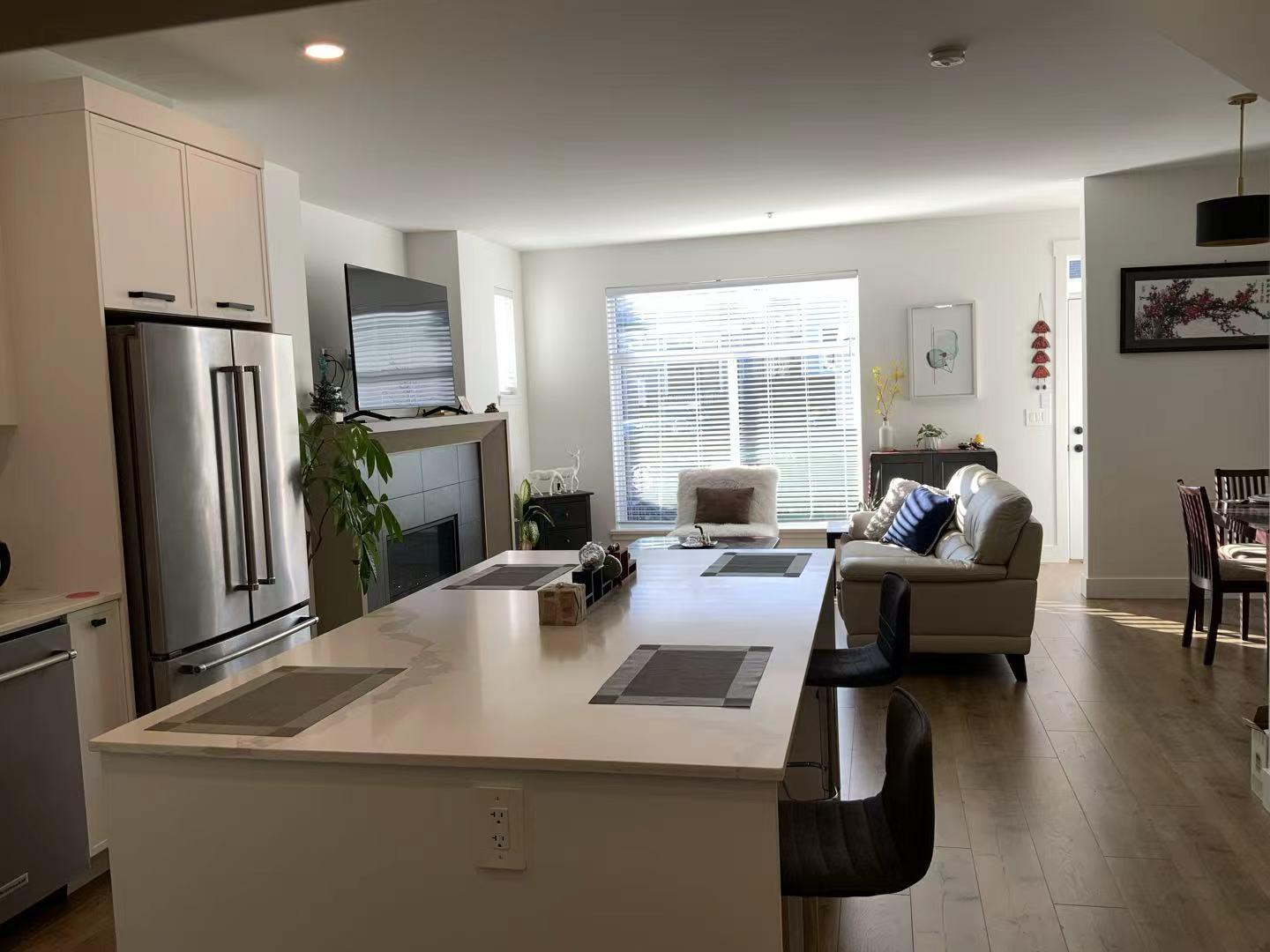 A modern kitchen with a refrigerator, stove, and oven.