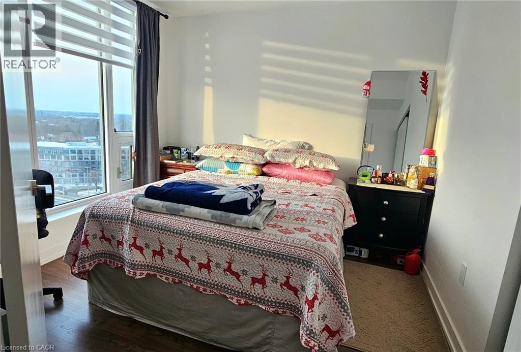 A bedroom with a bed covered in a red and white blanket.