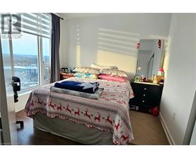 A bedroom with a bed covered in a red and white blanket.