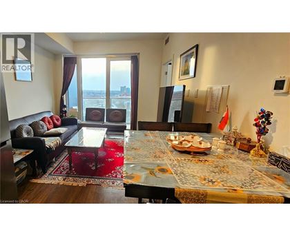 A living room with a dining table set for two with a view of the city.