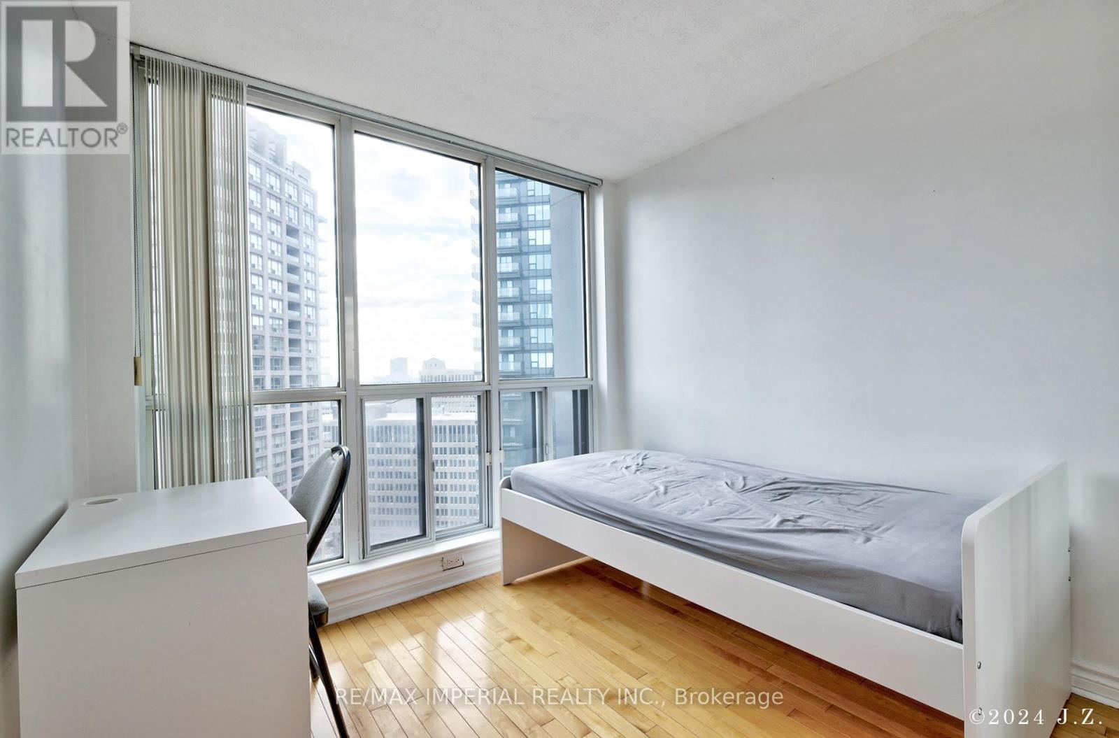 A bedroom with a large bed and a view of the city.