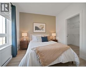 A bedroom with a large bed and a painting on the wall.
