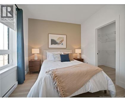 A bedroom with a large bed and a painting on the wall.
