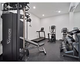 A gym with a variety of equipment including a treadmill, a stationary bike, and a bench press.