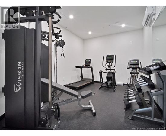 A gym with a variety of equipment including a treadmill, a stationary bike, and a bench press.