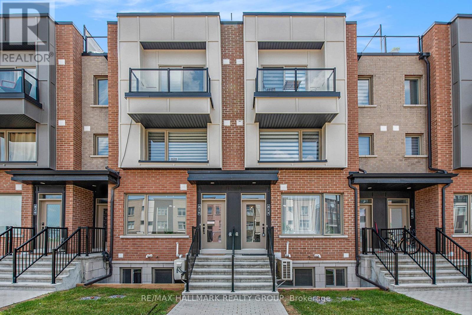 A modern apartment building with balconies and black railings.