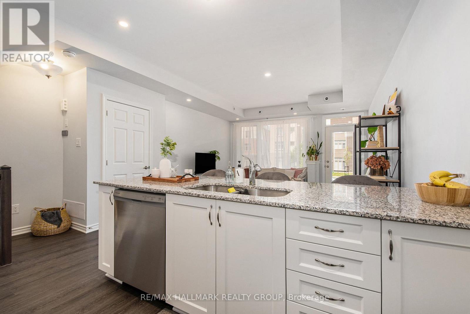 A kitchen with white cabinets and a granite countertop.