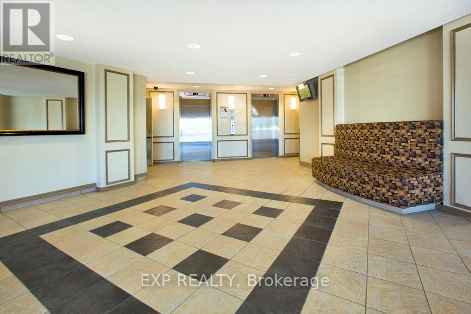 A hallway with a checkered tile floor and a wall of mirrors.