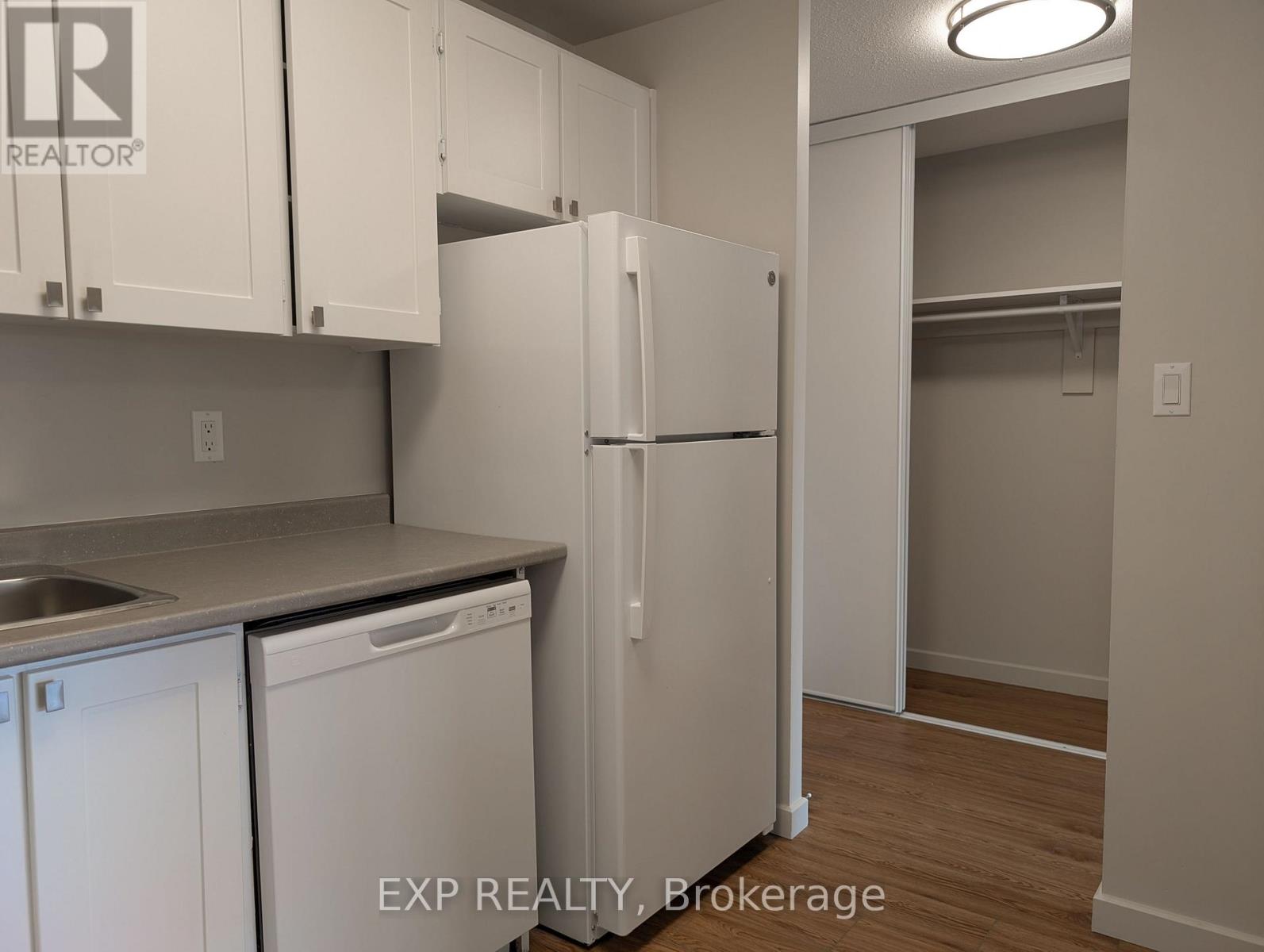 A kitchen with white cabinets and a white refrigerator.