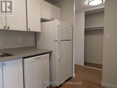 A kitchen with white cabinets and a white refrigerator.