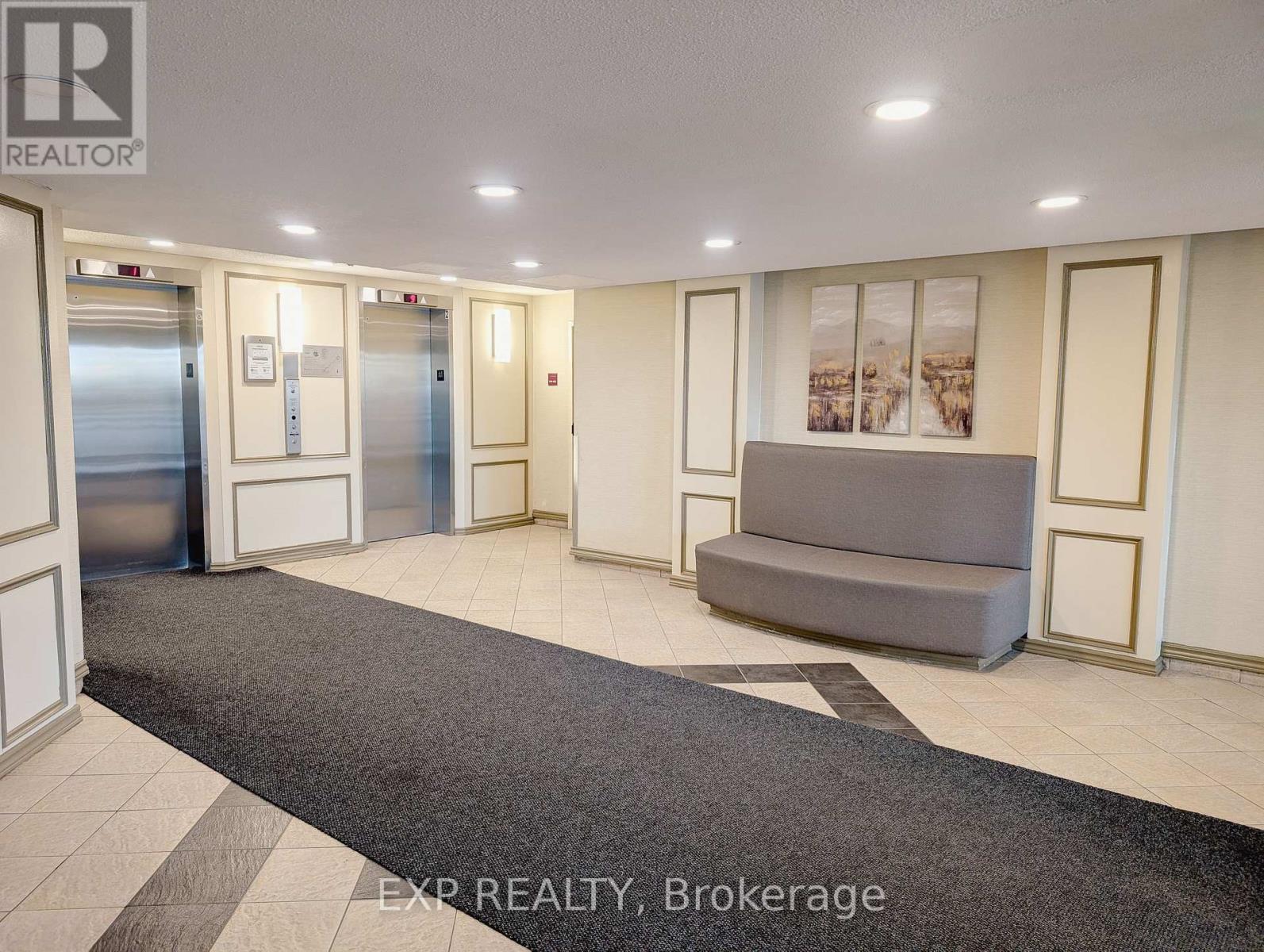 A brokerage office with a grey sofa and a framed picture on the wall.