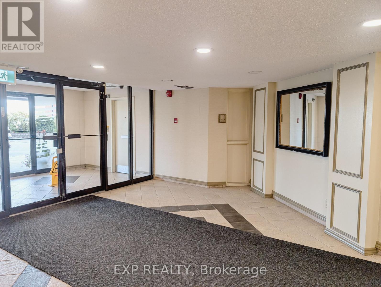 The image shows a hallway with a carpeted entrance and a sign that reads "EXP REALTY, Brokerage".
