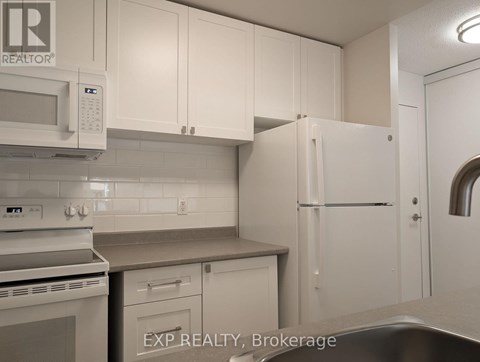 A kitchen with white cabinets and appliances.